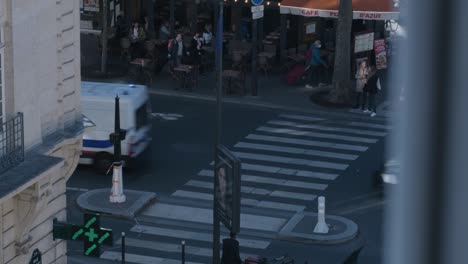 Esquina-De-La-Calle-En-París-Coches-De-Policía-Pasando-Delante-De-Una-Cafetería