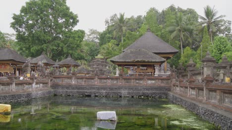 Pura-Gunung-Kawi-Sebatu-temple-in-Bali,-featuring-traditional-Balinese-structures-amid-verdant-surroundings-and-reflective-waters