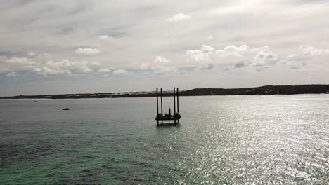 Silhouette-view-of-a-geological-survey-platform-with-sun-glistening-on-ocean