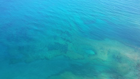 Aerial-pan-over-pacific-ocean-and-coral-reefs-from-high-above