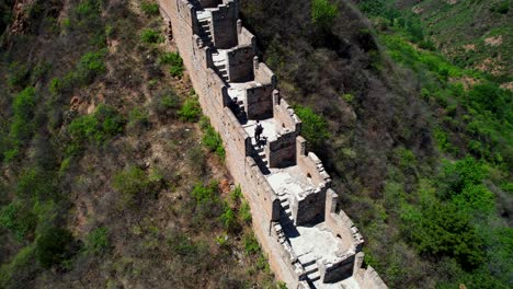 Aerial-orbit-shot-of-a-couple-walking-along-mountainous-Jinshanling-section-of-the-Great-Wall,-China