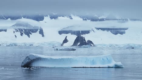 Icebergs-and-Mountains-Scenery-in-Antarctica-Landscape-Scene-with-Big-Dramatic-Ice-Formations,-Global-Warming-and-Climate-Change-on-Coast-with-Ocean-and-Sea-Water-on-Antarctic-Peninsula-in-Winter