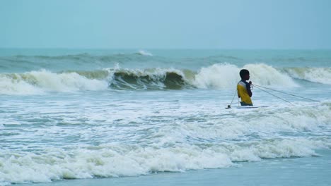 A-Young-Boy-Involved-in-the-Age-old-Practice-of-Net-Fishing-in-the-Sea-Waters-Off-Kuakata,-Bangladesh---Static-Shot