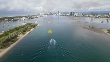 Popular-holiday-tourist-activities-on-a-busy-waterway-with-an-urban-city-skyline-in-the-distance