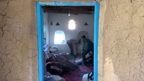 Limpieza-Dentro-De-Una-Casa-Abandonada-En-Un-Pueblo-Rural-Oasis-En-El-Desierto-En-Un-área-Remota-Campo-En-Marruecos-Cima-De-Una-Colina-Edificio-De-Ladrillos-De-Barro-Todavía-Marco-Escénico-Paisaje-De-La-Gente-Local-Irán-Medio-Oriente-Asia