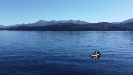 Aerial-orbital-shot-of-a-Kayak-with-two-people-in-the-lake-of-Nahuel-Huapi-in-Patagonia-with-Andes-mountain-range-in-the-background