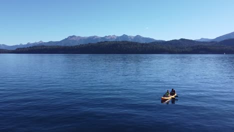 Luftaufnahme-Eines-Kajaks-Mit-Zwei-Personen-Im-See-Nahuel-Huapi-In-Patagonien-Mit-Der-Andenkette-Im-Hintergrund