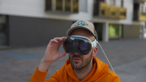 Man-uses-VR-virtual-reality-headset-outdoors-in-urban-setting,-close-up