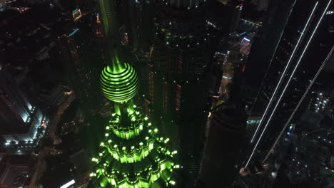 Drone-Volando-Sobre-Las-Torres-Gemelas-Petronas-Iluminadas,-Durante-La-Noche-En-Kuala-Lumpur