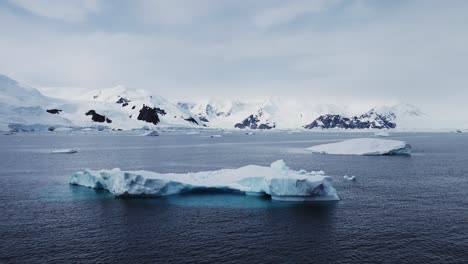 Mountains-Iceberg-and-Winter-Sea-in-Cold-Blue-Landscape-Scenery,-Antarctica-Seascape-with-Ice-and-Glacier-in-Dramatic-Beautiful-Coastal-Scene-on-Coast-on-Antarctic-Peninsula,-Moody-Blue-Atmosphric