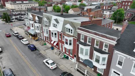 Red-colored-car-driving-on-street-in-traditional-neighborhood-of-USA