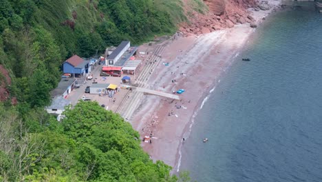 Scenic-aerial-view-of-secluded-Oddicombe-beach-and-sea-at-popular-holiday-destination-in-Babbacombe,-Devon,-England-UK