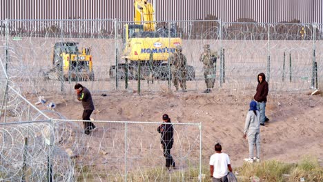 Seeking-Asylum:-Migrant-Talks-at-El-Paso-Border-Barrier