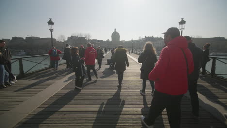 Crowded-ponts-des-arts-on-a-sunny-winter-day-with-a-lot-of-people-walking