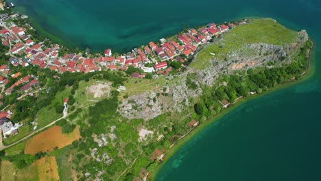 Halbinsel-Lin-Mit-Rot-Gedeckten-Häusern-Am-Smaragdgrünen-See,-Pogradec:-Ein-Idealer-Ort-Für-Einen-Ruhigen-Urlaub,-Luftaufnahme