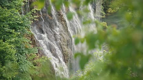 Side-view-of-a-cascading-waterfall-with-lush-greenery-framing-the-scene-in-Rastoke,-Croatia