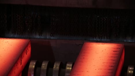 Close-up-of-glowing-hot-metal-in-an-industrial-steel-mill,-showcasing-the-intense-heat-and-machinery