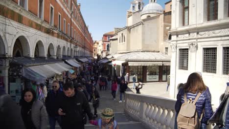 Tourists-walking-through-busy-market-street-in-Venice-city