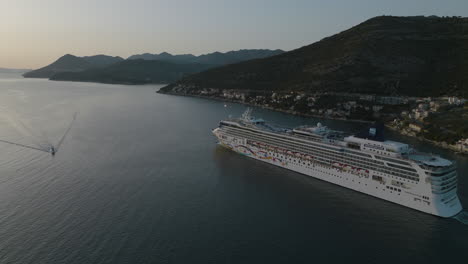 Scenic-Norwegian-Cruise-Ship-Sailing-Into-The-Sunset-Out-Of-Dubrovnik,-Croatia,-Aerial-5K-Drone