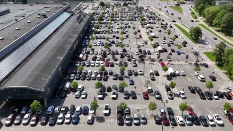 Ein-überfüllter-Parkplatz-Vor-Einem-Maxima-Shop-An-Einem-Sonnigen-Tag,-Luftaufnahme