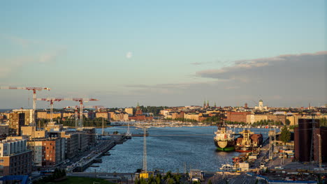 Timelapse-De-La-Luna-Desapareciendo-En-Las-Nubes-Sobre-El-Kalasatama-Iluminado-Por-El-Sol,-Helsinki