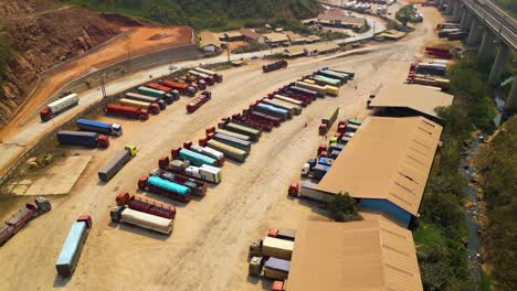 Aerial-view-of-cargo-trucks-in-the-Boten-Special-Economic-Zone,-Laos,-near-the-China-border,-concept-of-bustling-cross-border-trade-and-logistical-efficiency-at-a-vital-transportation-hub