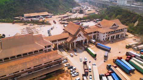 Aerial-of-cargo-trucks-navigating-the-customs-checkpoint-within-the-Boten-Special-Economic-Zone-in-Laos,-showcasing-cross-border-trade-and-streamlined-customs-processes-pivotal-to-economic-activity