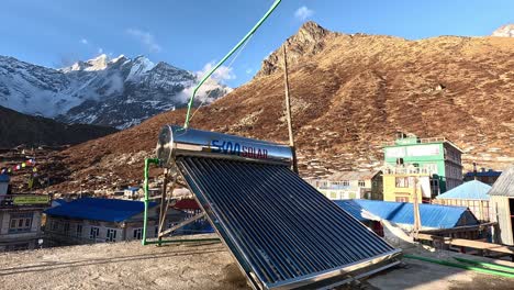 Solar-panels-on-a-rooftop-in-the-high-altitude-village-of-Kyanjin-Gompa,-Langtang-Valley-Trek,-with-the-towering-Langtang-Lirung-in-the-backdrop,-Himalayas,-Nepal