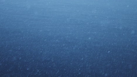 Snow-Snowing-Close-Up-Detail-with-Ocean-Sea-Water-in-Dark-Blue-Scene-in-Antarctica-on-Antarctic-Peninsula-in-Winter,-Snowflakes-Falling-in-Snow-Blizzard