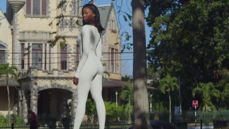 Una-Joven-Vestida-Con-Un-Traje-Blanco-Disfruta-De-Un-Día-En-La-Ciudad-Con-El-Castillo-De-Stollmeyer-Detrás-De-Ella.