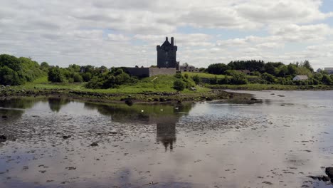 Preciosa-Toma-Reflejada-Desde-Una-Plataforma-Rodante-Que-Captura-El-Castillo-De-Dunguaire-Con-Cisnes-Deslizándose-Con-Gracia