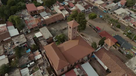 Aerial-shot-of-an-a-mexican-michoacan-church-in-old-town-and-green-trees