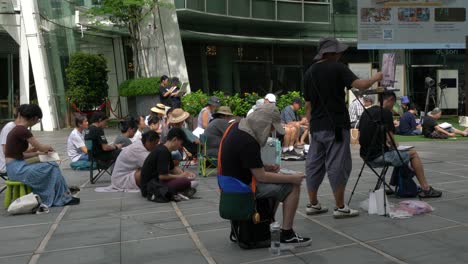 Scene-of-artists-painting-in-public-spaces-outside-the-Capitol-Building,-Singapore