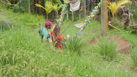 Una-Mujer-Joven-Con-Un-Vestido-Rojo-Se-Balancea-Juguetonamente-En-Los-Pintorescos-Campos-De-Arroz-De-Tegalalang,-Bali,-Indonesia.