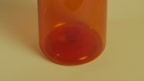 Slow-motion-high-angle-close-up-of-a-pill-bottle-as-it-fills-with-pills