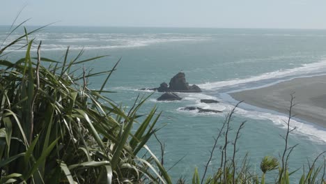 Vista-De-Las-Rocas-Y-El-Faro-En-La-Playa-De-Whatipu,-Omanawanui,-Nueva-Zelanda