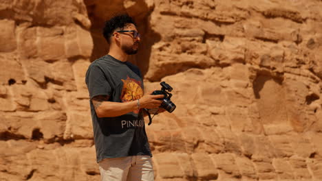 Man-Holding-a-Camera-in-Front-of-Temple-in-Aswan-Taking-Photos