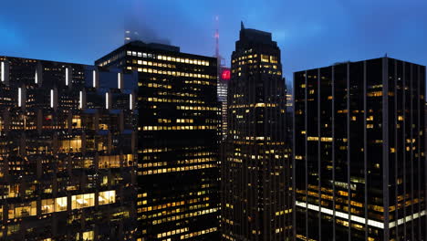 Aérea:-En-Medio-De-Los-Edificios,-Revelando-El-4-Times-Square,-Amanecer-Brumoso-En-Nueva-York