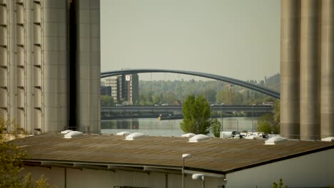 Escena-Urbana-Junto-Al-Río-Con-Un-Puente-Moderno-Y-Edificios-Industriales,-Día-Soleado,-Fondo-De-Paisaje-Urbano