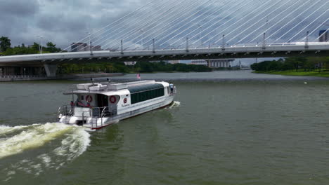 Aerial-view-around-a-ferry-driving-under-the-Seri-Wawasan-Bridge,-in-Malaysia