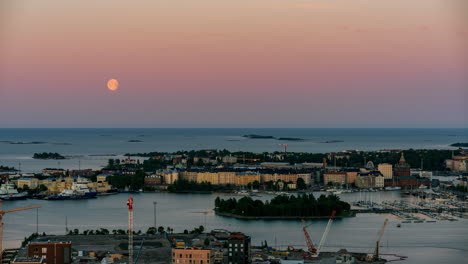 Timelapse-De-La-Luna-Llena-Moviéndose-Sobre-El-Mar,-Amanecer-En-Katajanokka,-Helsinki