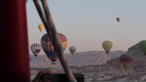 Globo-Aerostático-A-Lo-Lejos-Con-Un-Cielo-Despejado-Y-Montañas-Al-Fondo-En-Capadocia,-Turquía