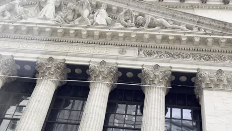 A-close-up-view-of-the-intricate-architectural-details-on-the-façade-of-the-New-York-Stock-Exchange,-the-classical-columns-and-sculptures-symbolize-strength-and-stability-in-global-finance