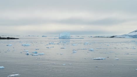 Icebergs-and-Sea-Ice-Orange-Sunset,-Antarctica-Iceberg-Scenery-with-Beautiful-Big-Large-Floating-Iceberg-in-the-Sea-Water-at-Sunrise-on-the-Coast-in-Beautiful-Winter-Seascape-on-Antarctic-Peninsula