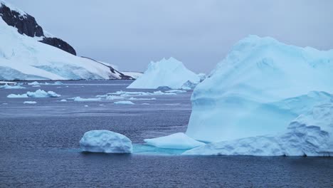 Ice-and-Icebergs-Floating-on-the-Sea-in-Antarctica,-Lots-of-Small-Bits-and-Pieces-of-Ice-on-the-Blue-Ocean-Sea-Water-on-the-Antarctic-Peninsula-in-a-Freezing-Frozen-Icy-Winter-Landscape-Seascape