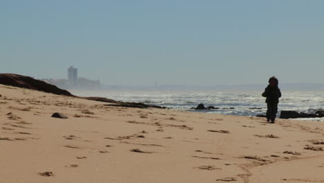 Niño-Corriendo-En-La-Playa-Con-Olas-Rompiendo-En-La-Costa-De-Buarcos,-Portugal