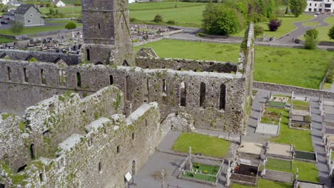 Claregalway-Friary-front-entrance-and-cemetery-with-tombstones,-orbit-around-mid-section-of-monastery