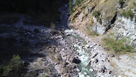 Drones-Vuelan-Sobre-El-Río-Con-Aguas-Cristalinas-De-Color-Turquesa-En-El-Valle-De-La-Montaña-En-Austria,-Europa