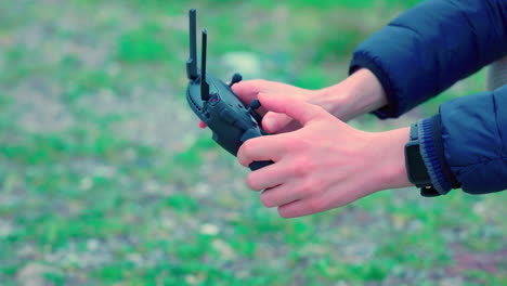 Close-shot-of-a-man-using-a-radio-to-take-off-a-drone