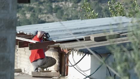 Un-Trabajador-De-La-Construcción-Calificado-En-El-Techo-De-Una-Casa-En-Jerusalén-Repara-Con-Su-Taladro-Profesional